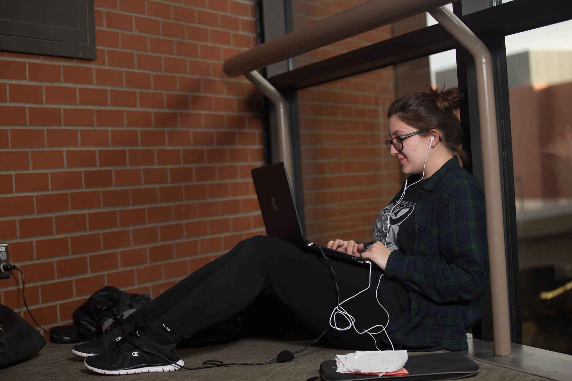 Student sitting down and typing on her laptop 